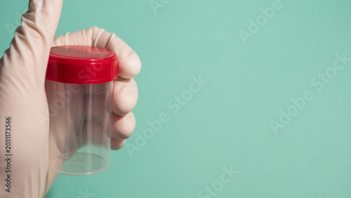 Tableau sur toile Gloved Hand Holding Empty Specimen Container with Red Cap — Medical Sample Colle