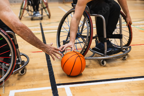 Bild auf Leinwand Athletes playing wheelchair basketball game on court
