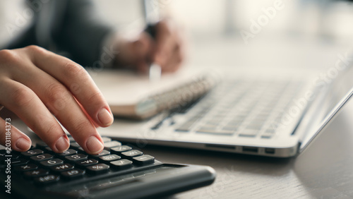 Billede på lærred Close-up view woman's hand using a calculator