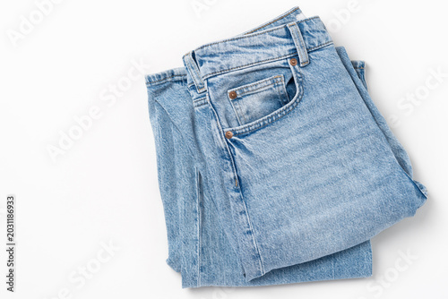 Fotografie Top view of folded light blue denim jeans on white background, copy space