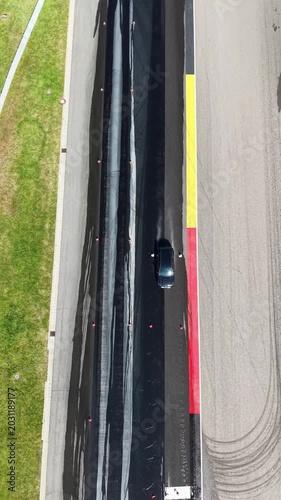 Vertical Aerial View of Car on Race Track with Colorful Kerb