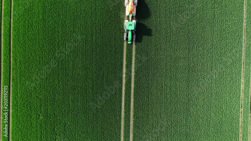 Vertical Aerial Top Down View of Crop Sprayer Tractor on Green Field