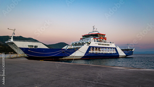 Tableau sur toile Passenger ferry moored at quiet harbor during sunset in Greece