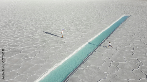 Canvas Print Aerial view of father and child playing soccer onwhite salt flats Salinas Jujuy