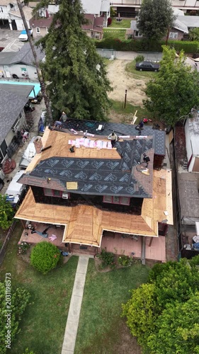 Aerial view of roof construction on a two story house with underlayment and exposed plywood 4k