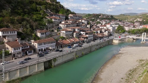 Cinematic Perspective of Drone Tracking Along Turquoise River with Ottoman Houses Parallax in Berat