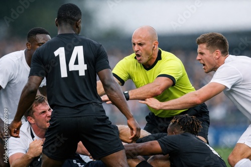Referee Intervening In Heated Soccer Match Altercation As Players Clash During On Field Dispute. Football World Cup Concept. Soccer World Cup Concept With Copy Space.