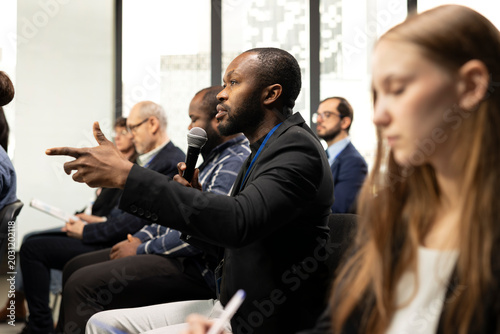 Slika na platnu African american man asking questions during conference discussion, engaging in professional debate and listening to convention speech