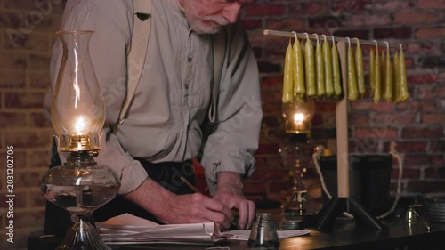vintage candle maker making notes on his inventory