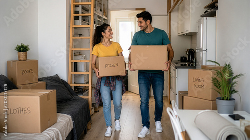 Young couple moving into small apartment with cardboard boxes