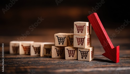Conceptual image of declining sales represented by shopping cart blocks and a red arrow.