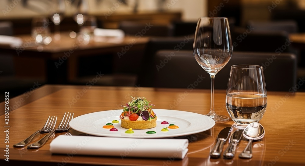 Fototapeta premium Elegant table setting in a luxury restaurant featuring gourmet dishes, fine glassware, and silver cutlery under soft warm ambient lighting, arrangement, lighting, tablecloth
