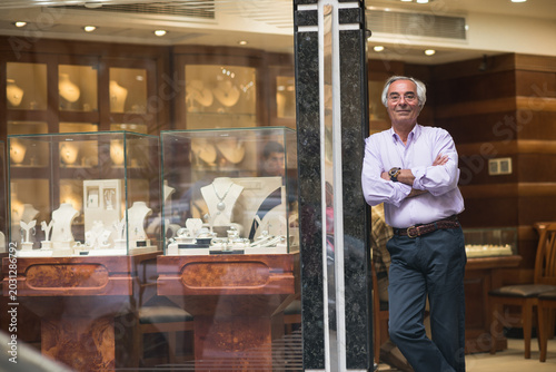 Fotografija Middle Eastern jewelry shop owner standing by display as couple shops for weddin