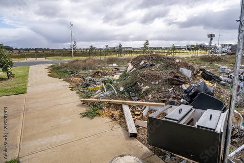 Tableau sur toile View of discarded building materials and household rubbish illegally dumped on a vacant suburban land allotment next to a public walking path in Tarneit, Melbourne, Australia