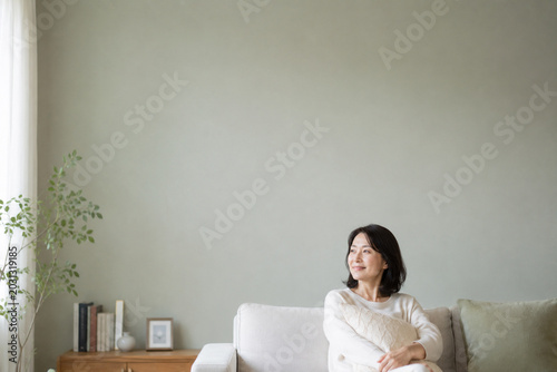 静かな午後にソファでくつろぐ40代日本人女性の上質ライフスタイルポートレート