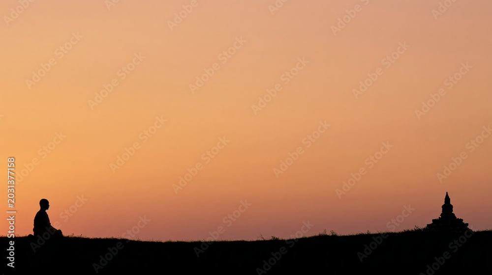 Fototapeta premium Buddhist monk meditating at sunset with temple