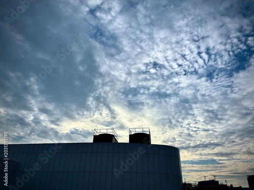 Dramatic Evening Cloudscape Over Modern Rooftop Silhouette with Textured Sky