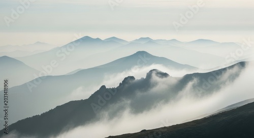 Mist Shrouded Mountain Ranges Under a Hazy Sky