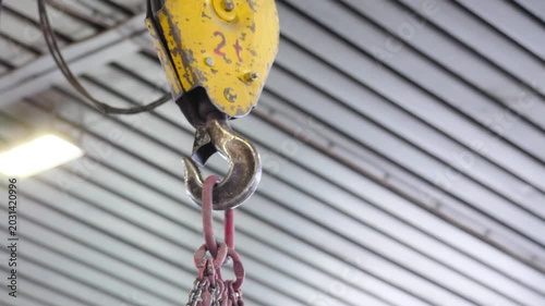 Crane beam hook moving in factory settings. Industrial crane beam with hook and cable moves across factory. metallurgical production, metal processing, heavy industry manufacturing process, 4 k video