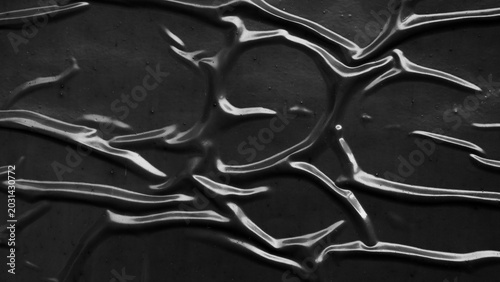 Abstract black wrinkled plastic texture background, dark crumpled surface with light reflections