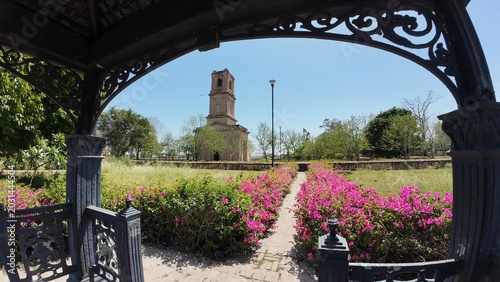 Scenic View of the Historic Cantonment Church Tower Framed by an Iron Gazebo and Vibrant Bougainvillea Flowers in Karnal