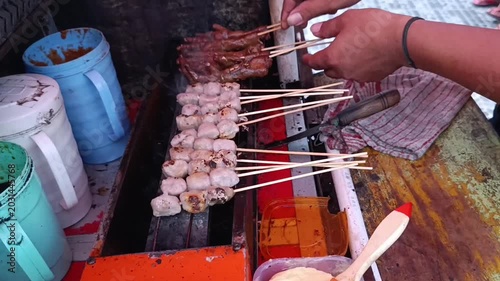 Skewered Meat and Grilled Delicacies Cooking on Open Grill in Market Setting
