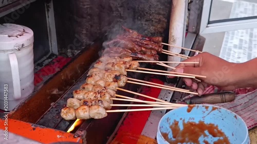 Skewered Meat Grilling on Open Flame Aiming for Smoky Delicious Flavor in Outdoor Street Kitchen