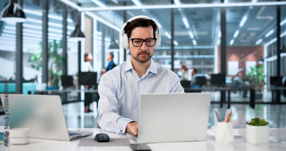Fototapeta premium Focused Man Manages Two Laptops