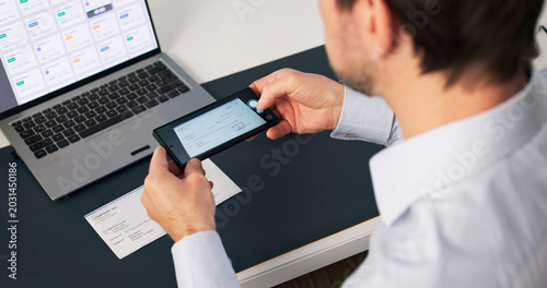 Cuadro en lienzo Older Man Uses Smartphone App To Deposit Paycheck Remotely