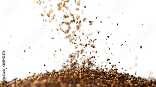 Falling brown granular particles creating a textured pile on a clean white background