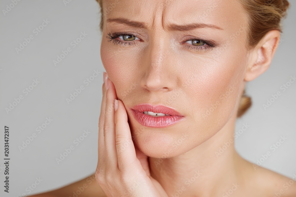 Obraz premium Close-up portrait of a woman experiencing tooth pain, conveying dental discomfort and health concern