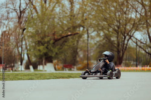 Canvas Print Happy Little Child Driving a Kart in Public Green Park