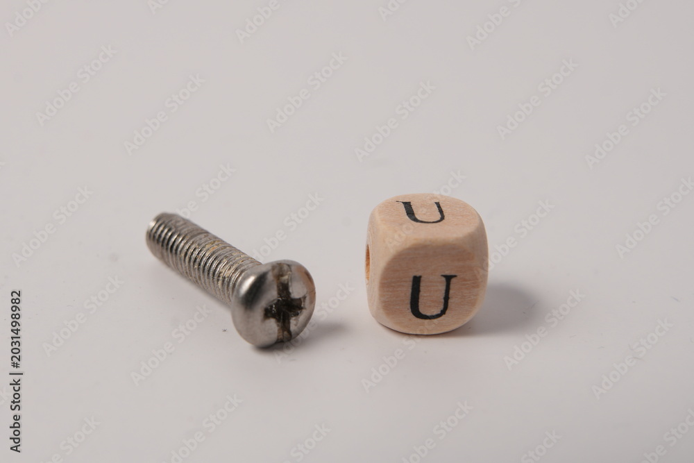 Fototapeta premium Single Metal Screw and Wooden Cube with Letter U for Connection Concept on White Studio Background