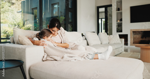 Foto Mom, home and hug with child on couch, bonding and emotional support for girl and family connection