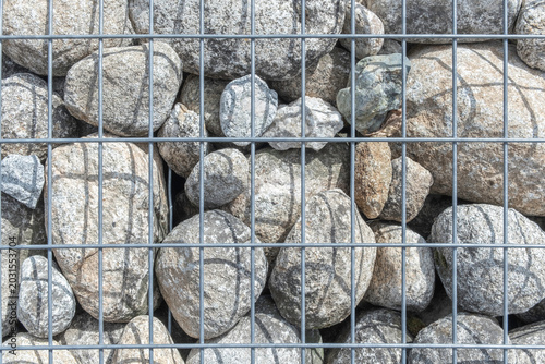 Stones in aluminum mesh. Stone and mesh background.