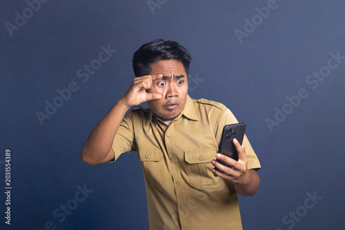 Photos Indonesian civil servant widening eye with fingers in shock while looking at sma