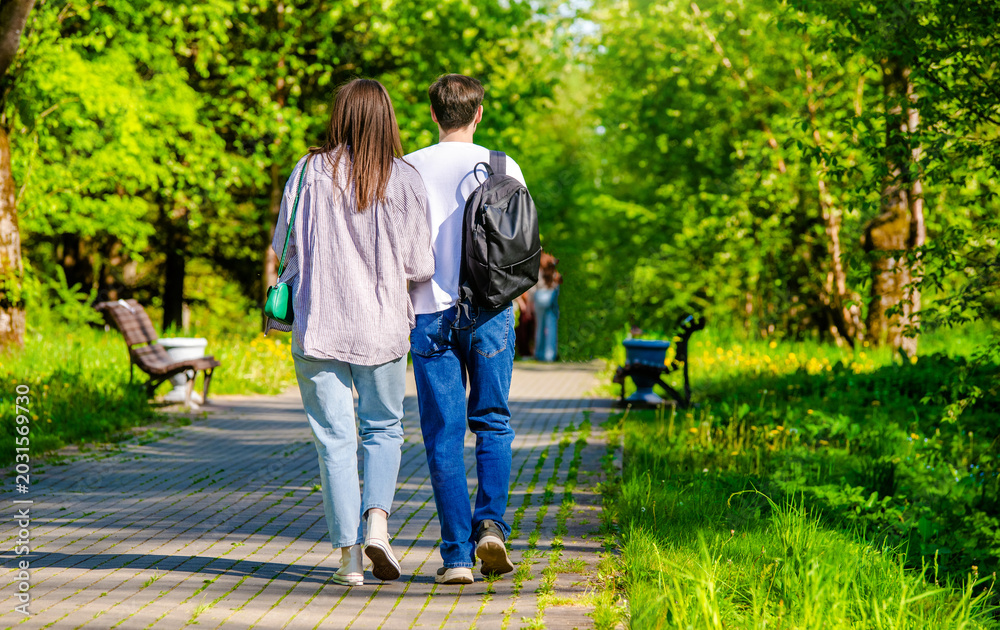 Obraz premium A guy and a girl walk along the path in the city Park 