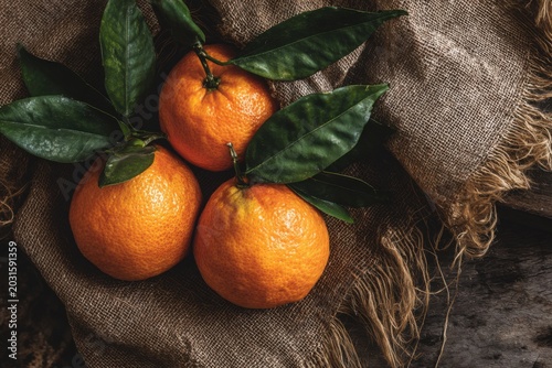 Ripe Oranges with Green Leaves on Rustic Fabric