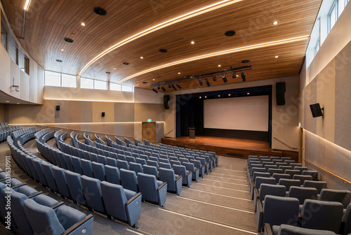 Contemporary conference hall interior with empty seating, stage, and professional event space