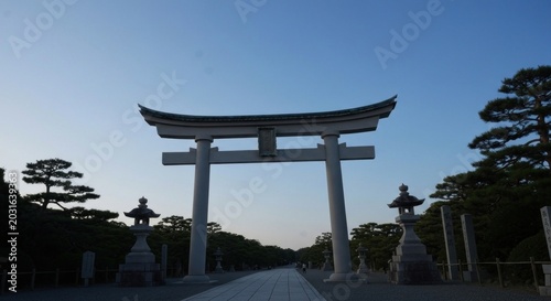 Grand white gate leading to a distant path, trees lining sides