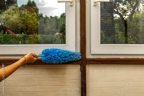 Housekeeper Holding Cobweb Brush for Removing Spiders in Summer Cottage