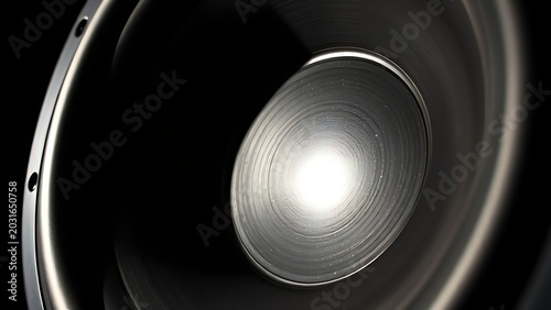 Close-up of subwoofer cone with motion blur under strobe light.