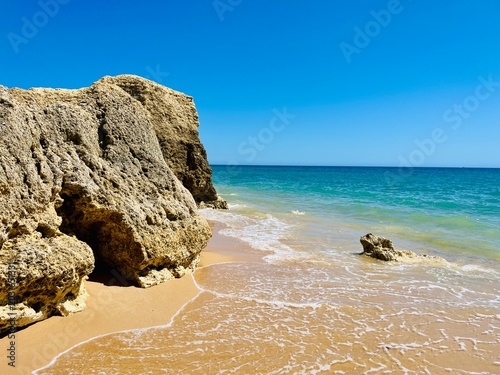 Gros rocher sur plage et eau turquoise en Algarve – paysage côtier et nature sauvage