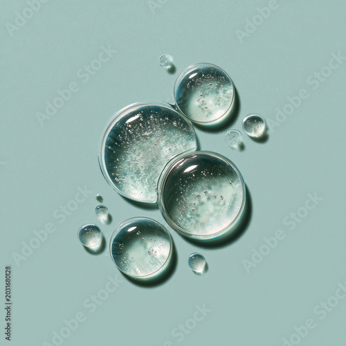 Macro shot of clear liquid bubbles on a pale green surface