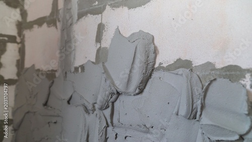 Textured grey plaster applied to block wall during home renovation