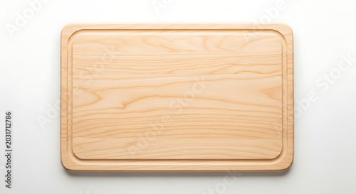 A light wood cutting board with a recessed edge on a white surface shown from a top down view
