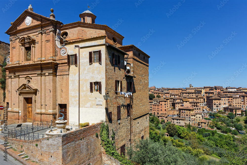 Naklejka premium Church and a view on Siena. The city was an important city in medieval Europe, and its historic centre is a UNESCO World Heritage Site