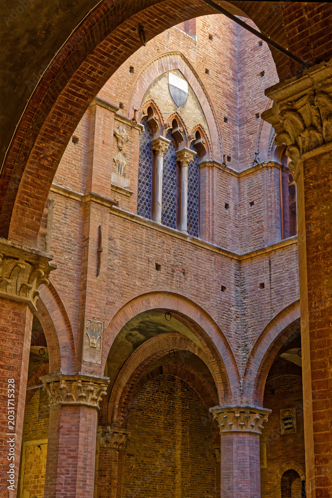 Fototapeta premium Architectural detail of Palazzo Pubblico, historic palace on the Piazza del Campo in Siena. It is one of the principal landmarks of the historic center.