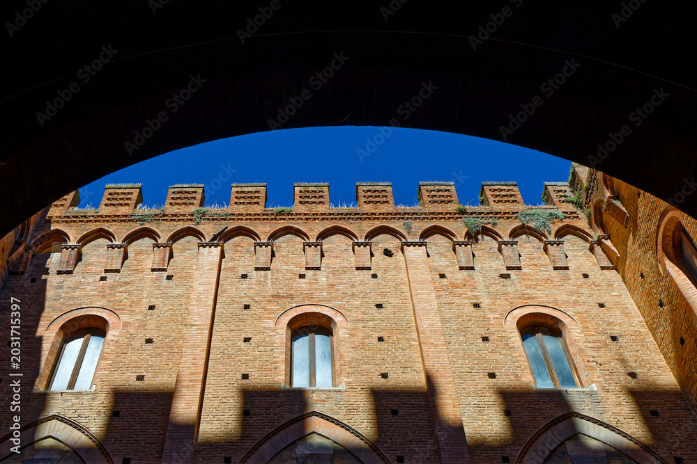 Fototapeta premium Architectural detail of Palazzo Pubblico, historic palace on the Piazza del Campo in Siena. It is one of the principal landmarks of the historic center.