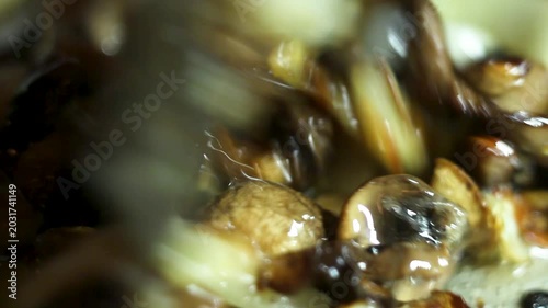 Fresh mushrooms and onions sizzling in hot pan during cooking process